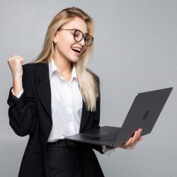portrait-young-happy-business-woman-with-laptop-with-win-gesture